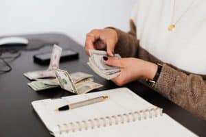 Blog Woman counting money. How to use money and spend money wisely, understanding wealth.